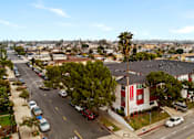 Thumbnail 2 of 9 - A street view of a residential area with cars parked on the side of the road.