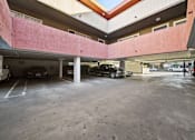 Thumbnail 8 of 8 - A parking garage with cars parked in it.
