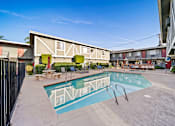 Thumbnail 10 of 23 - A swimming pool surrounded by a fence and chairs.