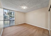 Thumbnail 15 of 22 - Empty room with wooden floor and white walls.
