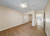 Thumbnail 13 of 22 - A room with a white ceiling and wooden flooring.