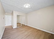 Thumbnail 18 of 22 - A room with a white ceiling and wooden flooring.