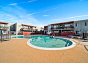 Thumbnail 2 of 22 - A round above ground pool with a white border and a brown sandy area around it.