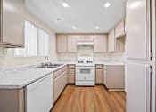 Thumbnail 5 of 15 - A kitchen with white appliances and wooden floors.