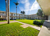 Thumbnail 6 of 21 - A sunny day at the apartment complex with a clear blue sky.