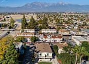 Thumbnail 1 of 2 - A residential area with houses and trees in the foreground and mountains in the background.