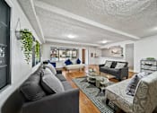 Thumbnail 18 of 23 - A living room with grey couches and a coffee table.