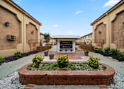 Thumbnail 8 of 23 - A garden in front of a building with a sign that reads "Welcome to Ansonia".