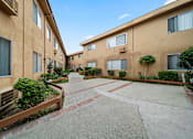 Thumbnail 10 of 23 - A courtyard surrounded by apartment buildings with a clear blue sky.