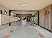 Thumbnail 16 of 23 - A long hallway with a brick floor and a white ceiling.