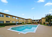 Thumbnail 20 of 23 - A swimming pool in front of apartment buildings.