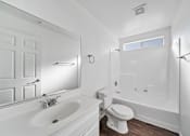 Thumbnail 8 of 10 - A white bathroom with a sink, toilet, and bathtub.
