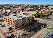 Thumbnail 2 of 10 - A view of a city from a high vantage point with buildings, cars, and a clear sky.