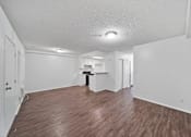 Thumbnail 9 of 10 - A room with wooden floors and white walls.