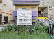 Thumbnail 2 of 4 - A sign for Forest View Apartments is in front of a building.