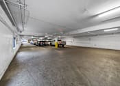 Thumbnail 1 of 4 - A parking garage with a concrete floor and white walls.