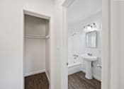 Thumbnail 3 of 9 - A white bathroom with a sink and a mirror.