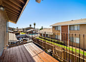 Thumbnail 5 of 20 - A balcony with a wooden floor and a metal railing.
