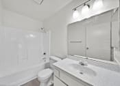 Thumbnail 20 of 20 - A white bathroom with a toilet, sink, and bathtub.