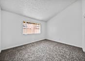 Thumbnail 19 of 20 - A room with a carpeted floor and a window with blinds.