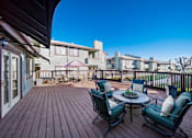 Thumbnail 10 of 13 - A wooden deck with a table and chairs overlooking a row of houses.