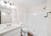 Thumbnail 6 of 13 - A white bathroom with a sink, toilet, and bathtub.