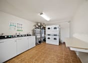 Thumbnail 4 of 5 - A laundry room with a washer and dryer.