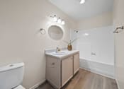 Thumbnail 10 of 11 - A bathroom with a toilet, sink, and mirror.