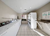 Thumbnail 7 of 11 - A laundry room with washers and dryers.