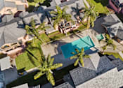 Thumbnail 3 of 13 - A bird's eye view of a neighborhood with a pool and palm trees.