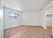 Thumbnail 13 of 20 - Empty room with a window and wooden flooring.