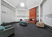 Thumbnail 9 of 20 - A living room with a grey couch and a red brick fireplace.