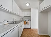 Thumbnail 16 of 20 - A kitchen with white cabinets and a granite countertop.