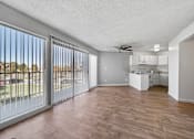 Thumbnail 8 of 20 - A spacious room with a sliding glass door and a ceiling fan.