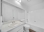 Thumbnail 11 of 12 - A white bathroom with a sink, toilet, and bathtub.