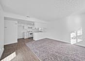 Thumbnail 8 of 12 - A spacious living room with a grey carpet and wooden flooring.