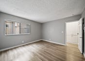 Thumbnail 14 of 19 - A room with a window and wooden flooring.