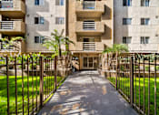 Thumbnail 5 of 10 - A concrete building with a gate in front of it.