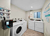 Thumbnail 8 of 10 - A laundry room with a washing machine and a dryer.