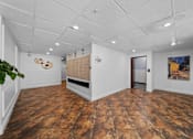 Thumbnail 1 of 10 - A room with a wooden floor and a white ceiling.