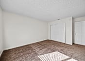 Thumbnail 11 of 16 - A room with two white doors and a carpeted floor.