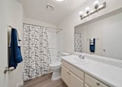 Thumbnail 16 of 17 - A bathroom with a toilet, sink, and shower curtain.