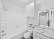Thumbnail 13 of 13 - A white bathroom with a toilet, sink, and bathtub.