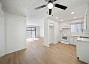 Thumbnail 6 of 13 - A white kitchen with a fan on the ceiling.
