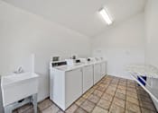 Thumbnail 11 of 13 - A laundry room with a washer and dryer.