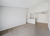 Thumbnail 10 of 13 - A spacious room with a kitchenette and a ceiling fan.