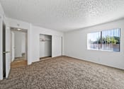 Thumbnail 1 of 11 - A room with a carpeted floor and a window with blinds.