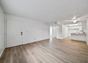 Thumbnail 11 of 11 - A room with a white door and a wooden floor.