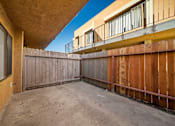 Thumbnail 6 of 11 - A backyard with a wooden fence and a concrete floor.