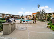 Thumbnail 6 of 16 - A pool in a courtyard surrounded by apartment buildings.